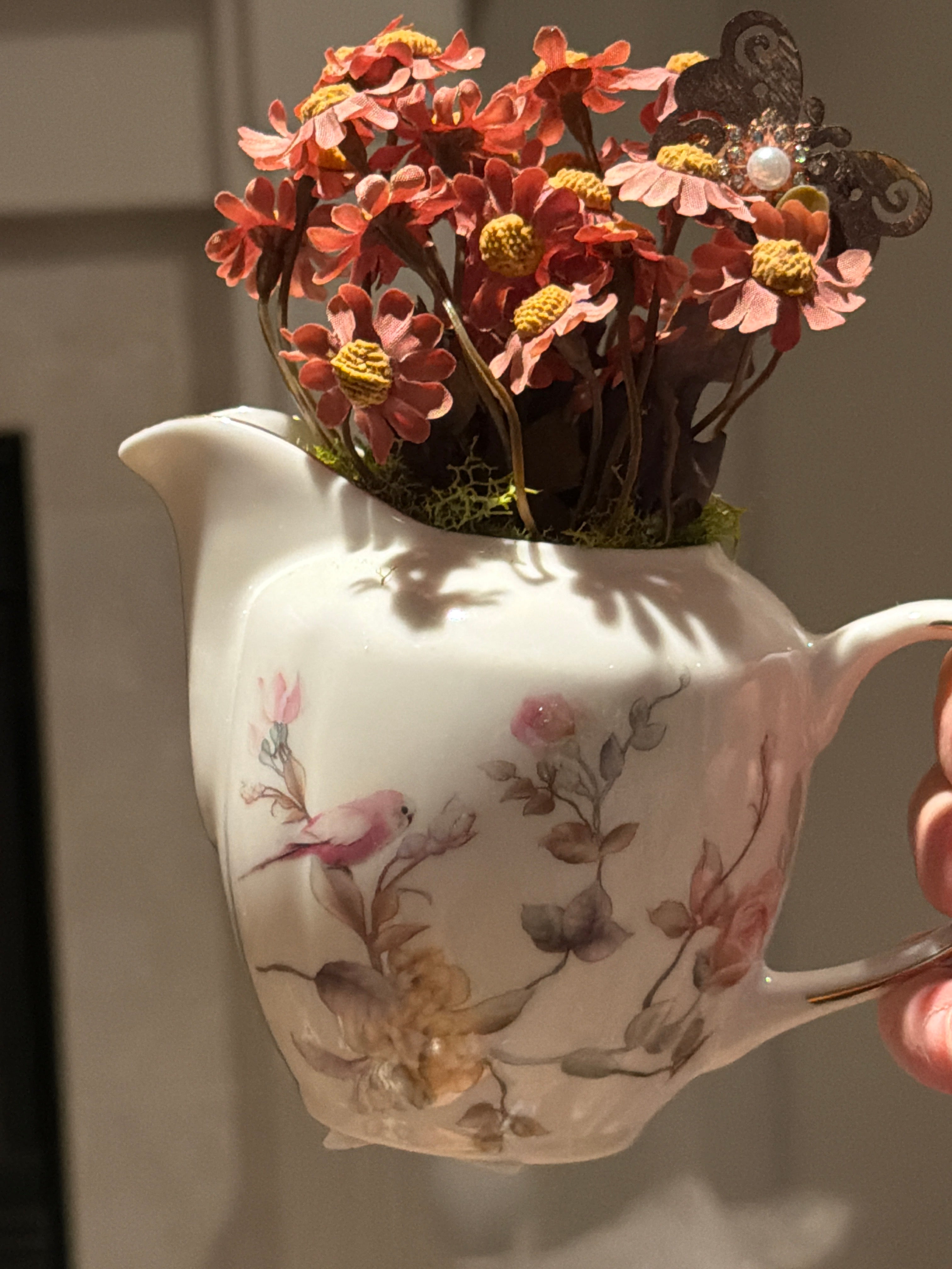 Decorative Pink Floral Arrangement in White Ceramic Pitcher with Butterfly Accent