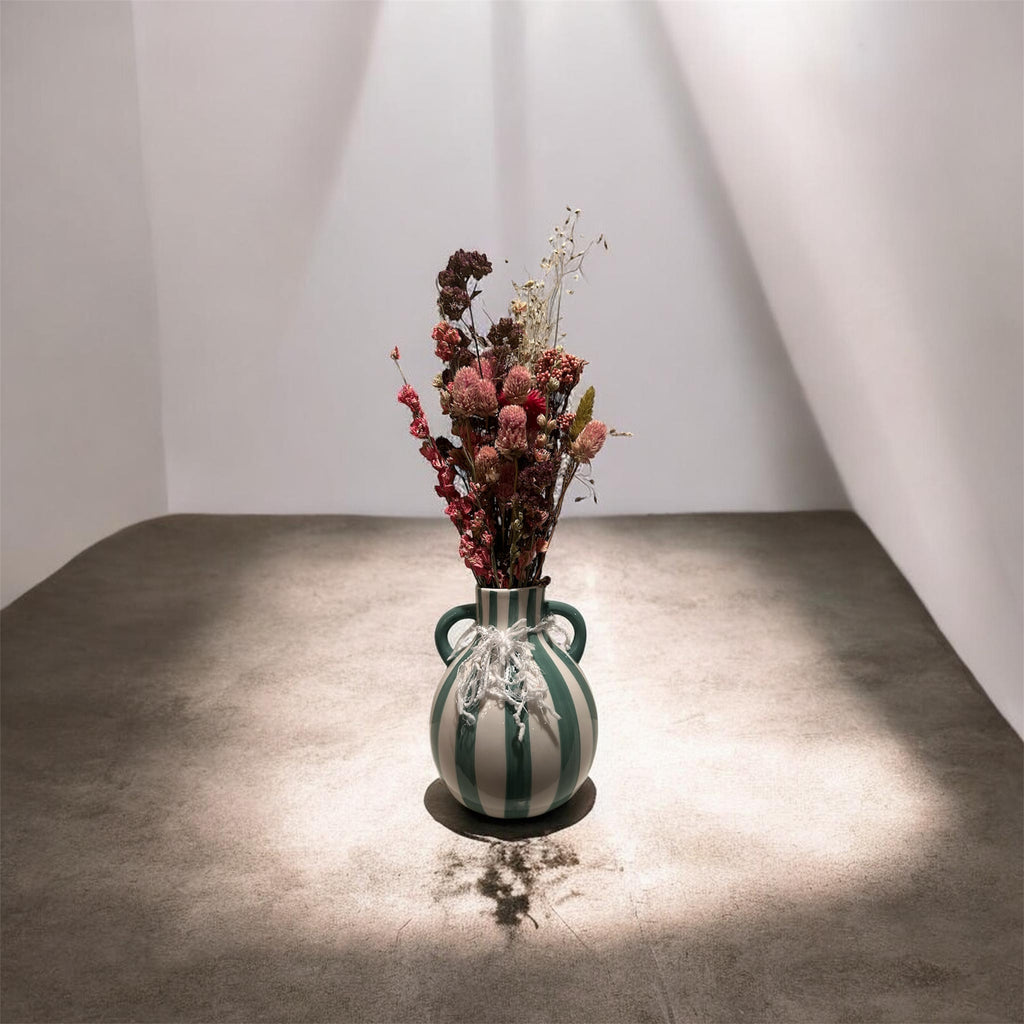 Green striped vase with dried floral arrangement