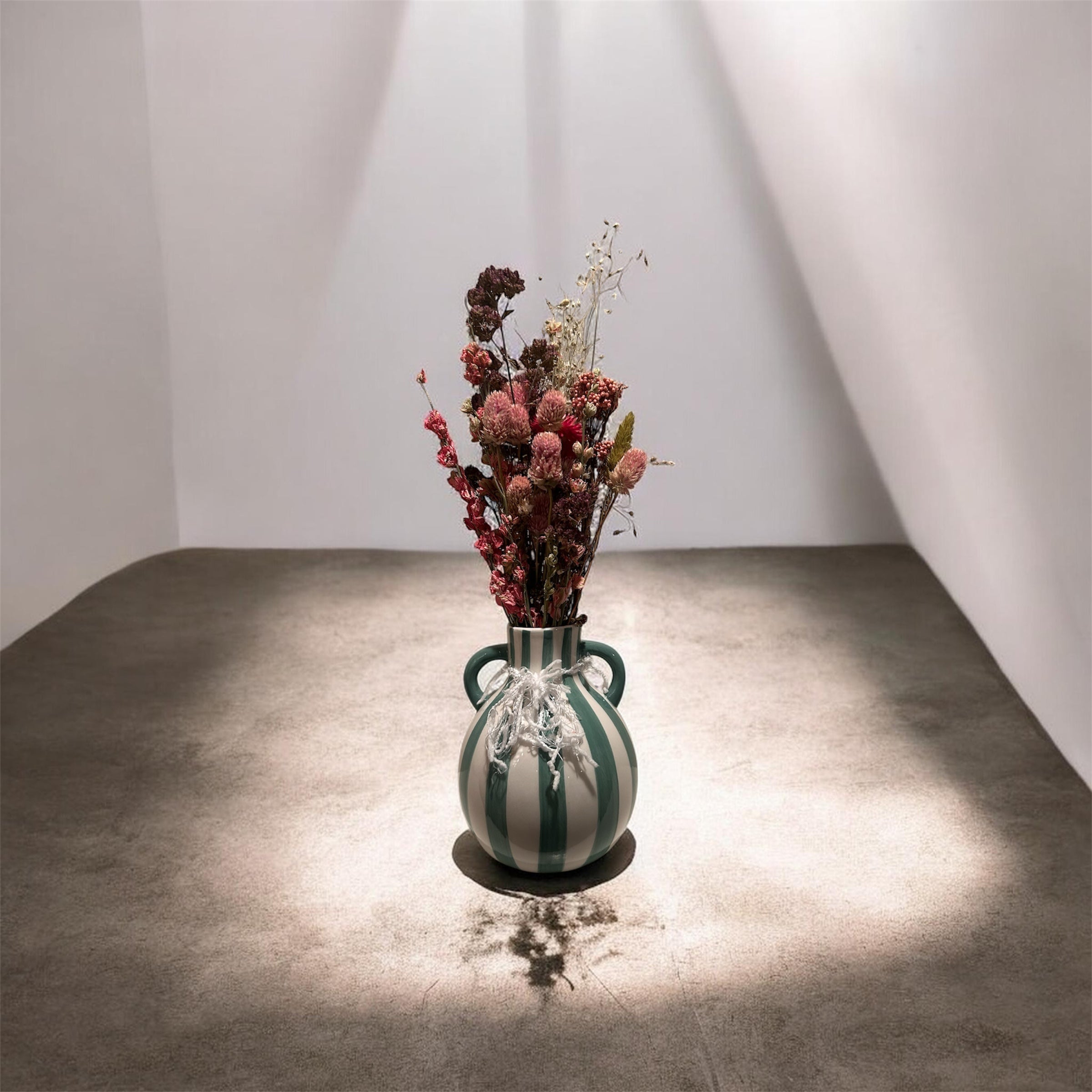 Green striped vase with dried floral arrangement