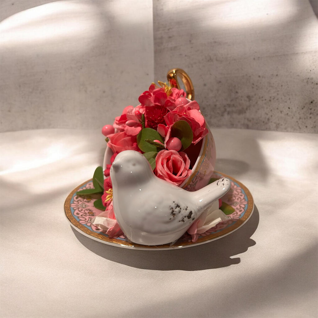 Pink teacup/saucer arrangement with white bird