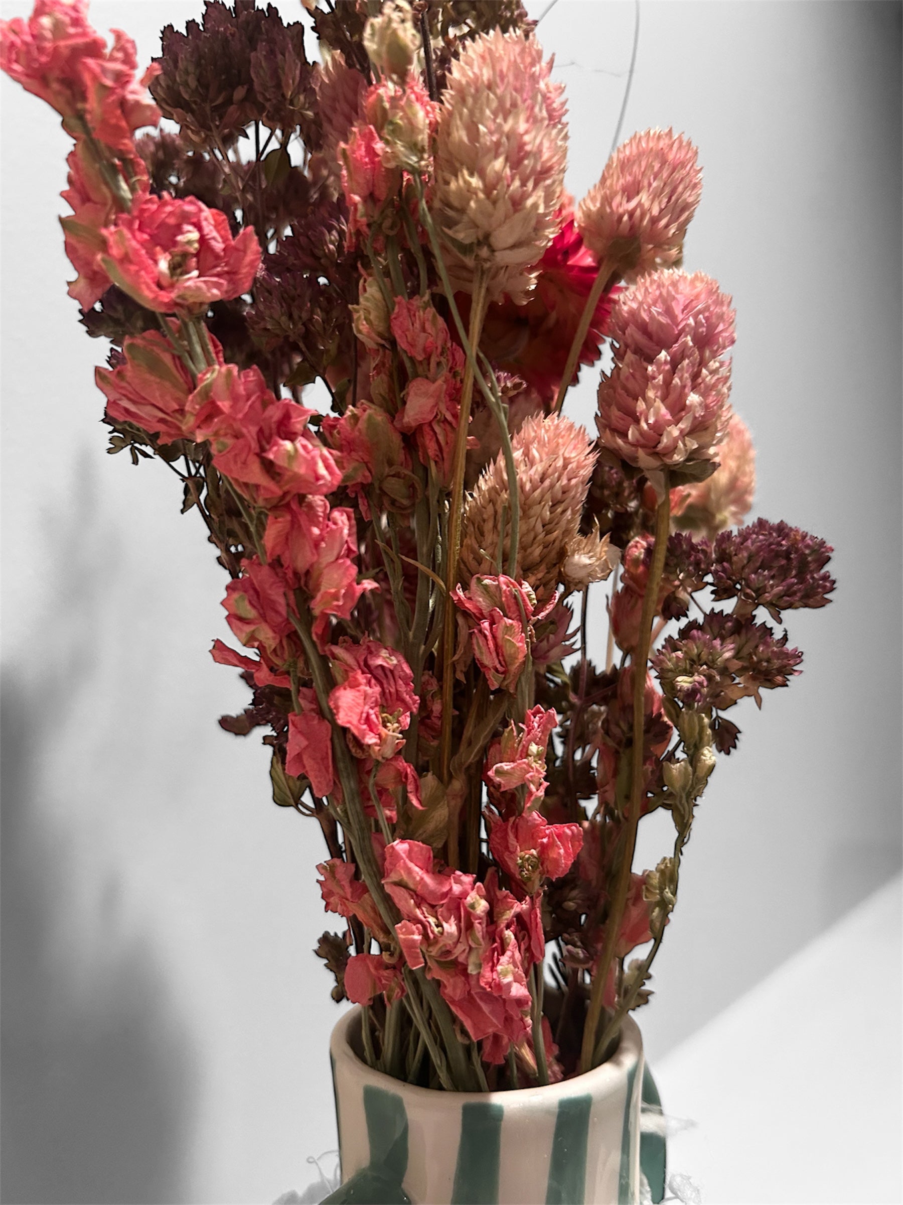 Green striped vase with dried floral arrangement