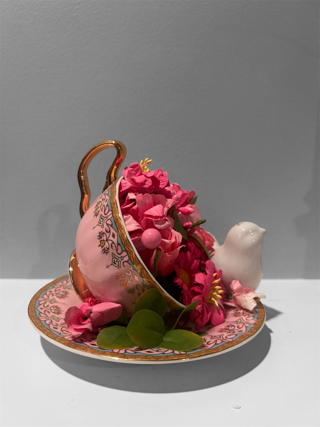 Pink teacup/saucer arrangement with white bird