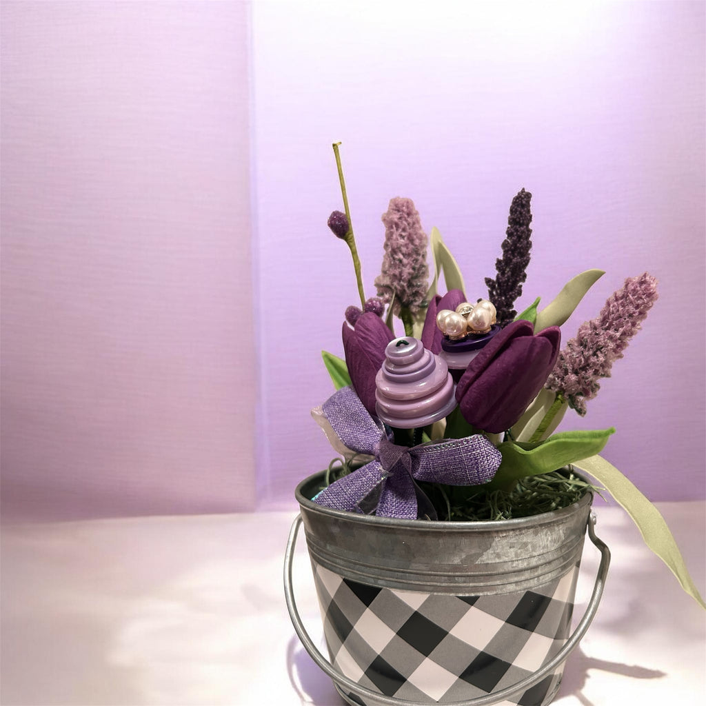 Purple flowers in white/black checked metal bucket arrangement