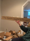 The earth laughs in flowers wood sign