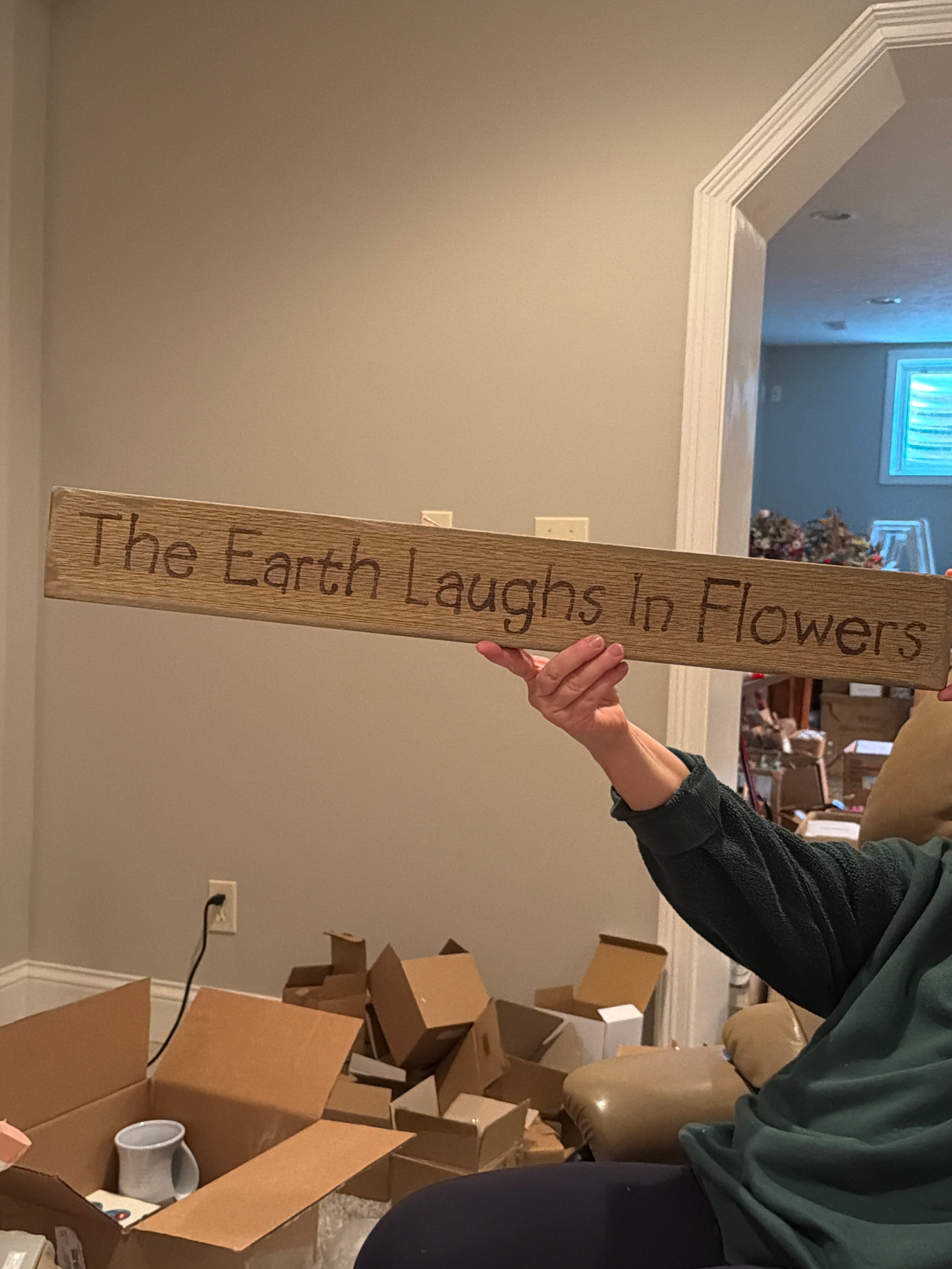 The earth laughs in flowers wood sign
