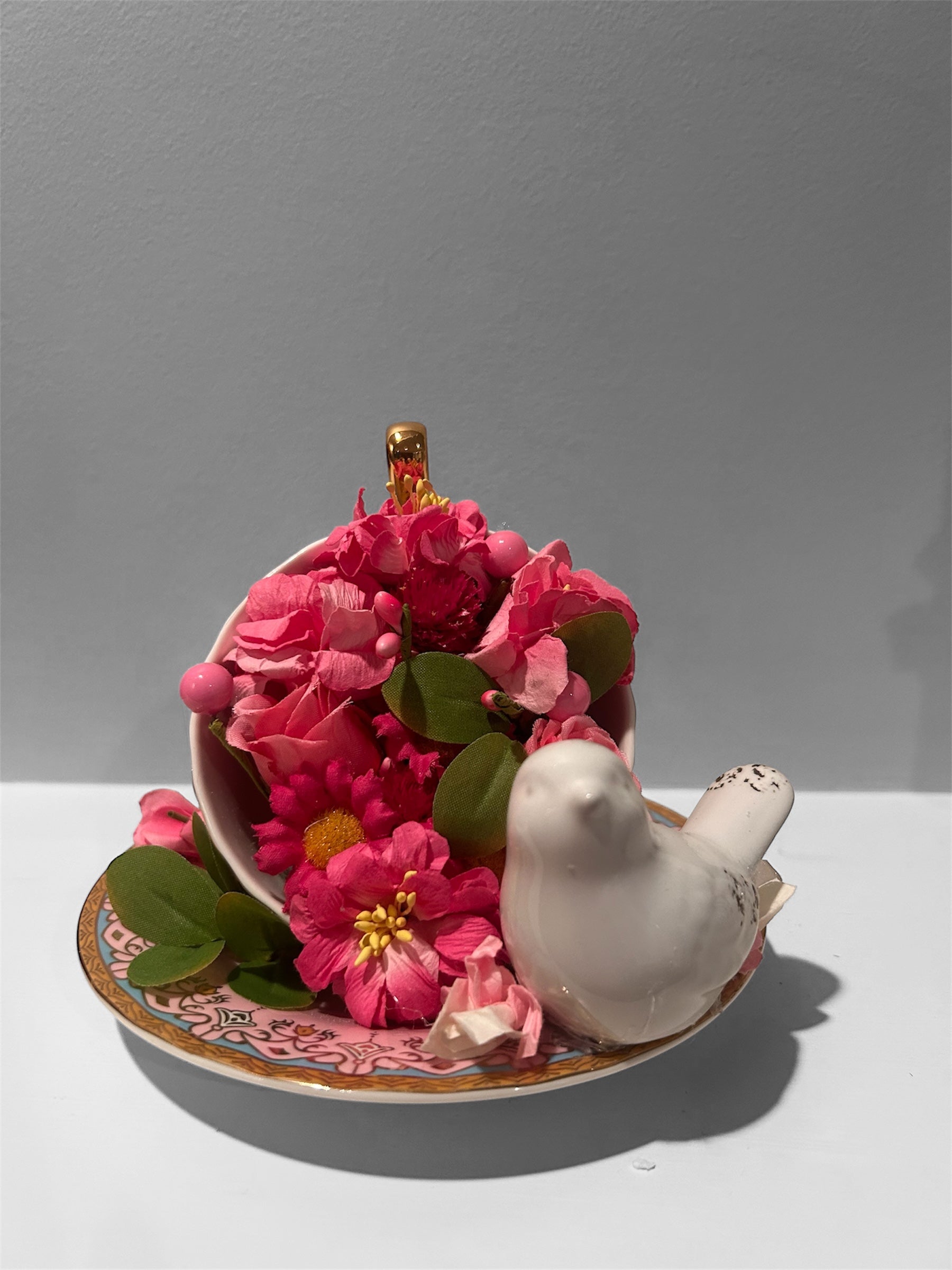 Pink teacup/saucer arrangement with white bird