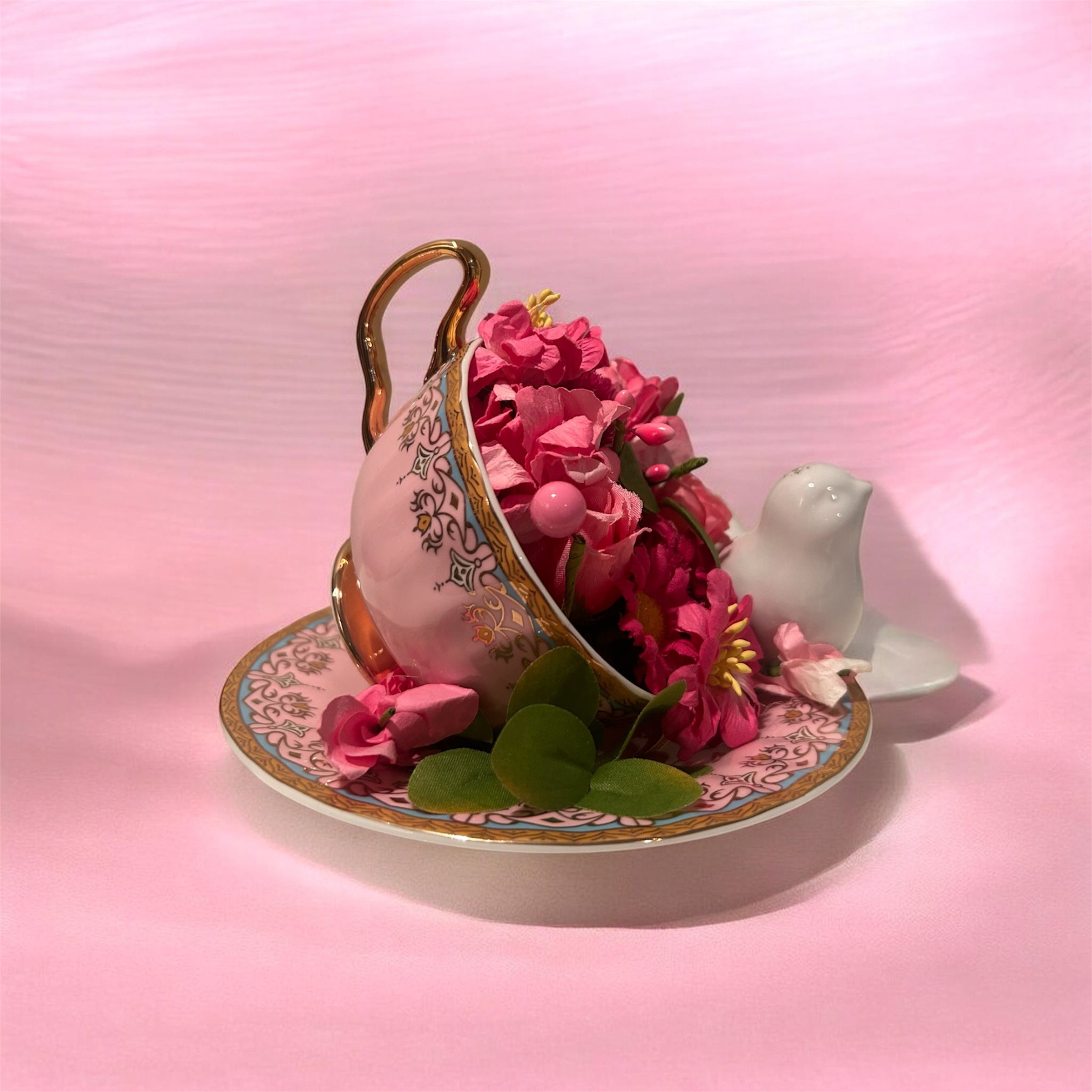 Pink teacup/saucer arrangement with white bird