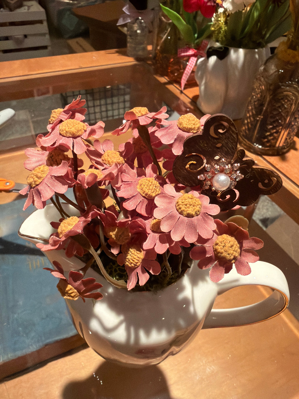 Decorative Pink Floral Arrangement in White Ceramic Pitcher with Butterfly Accent