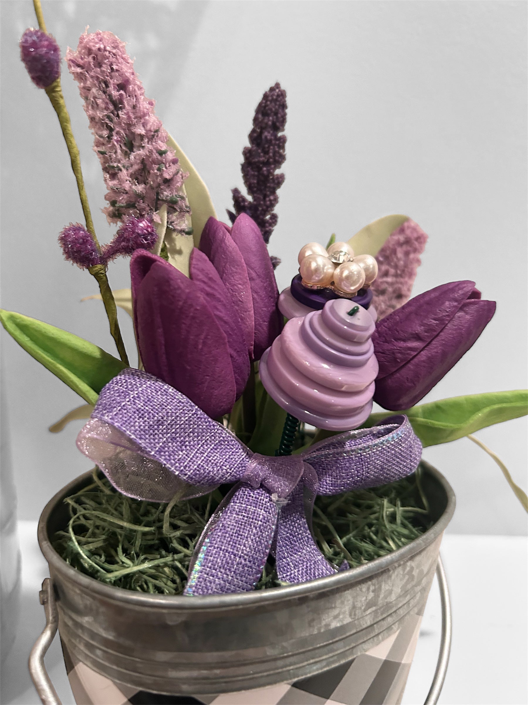 Purple flowers in white/black checked metal bucket arrangement