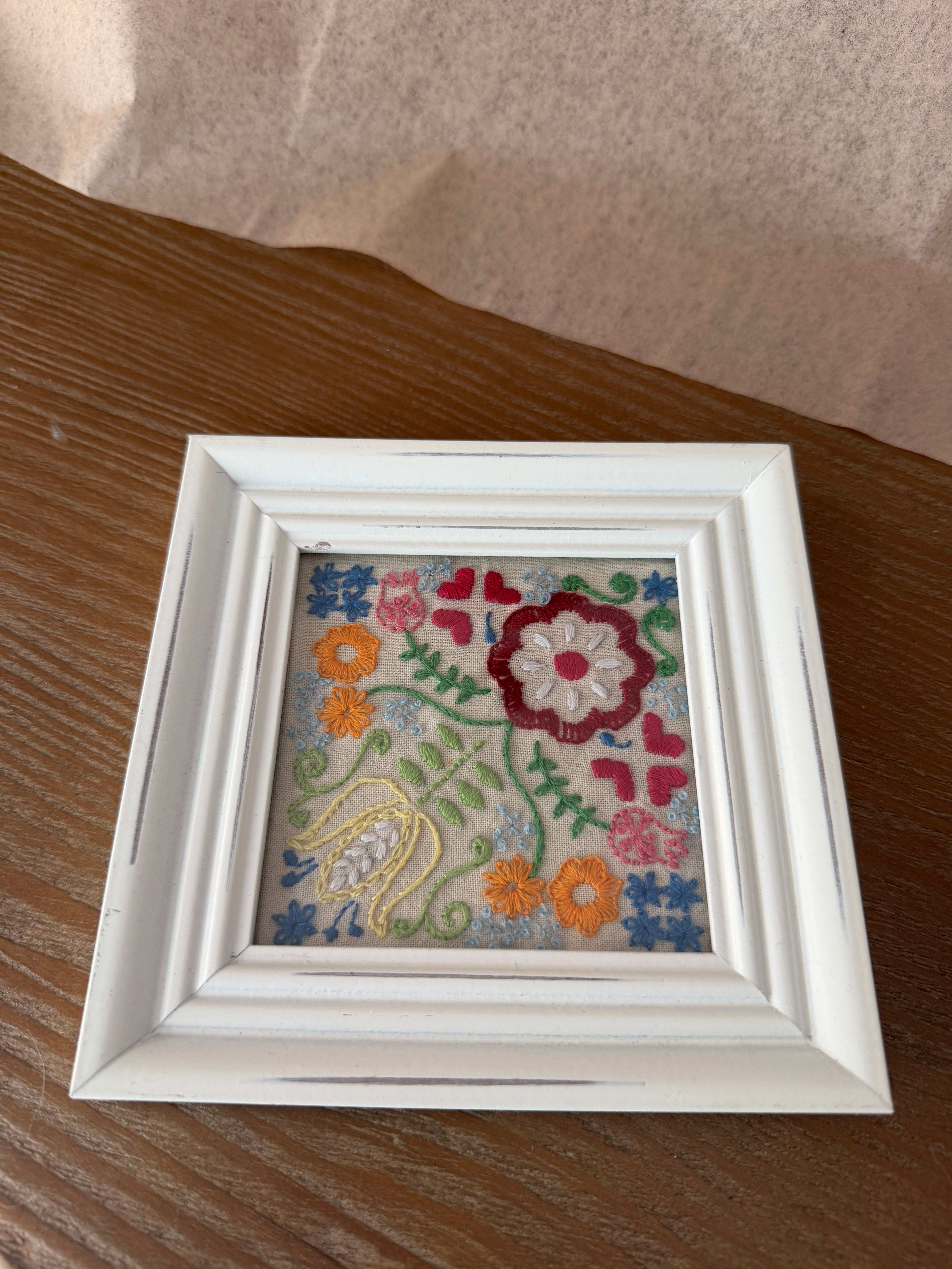 Embroidered garden design in white, square frame