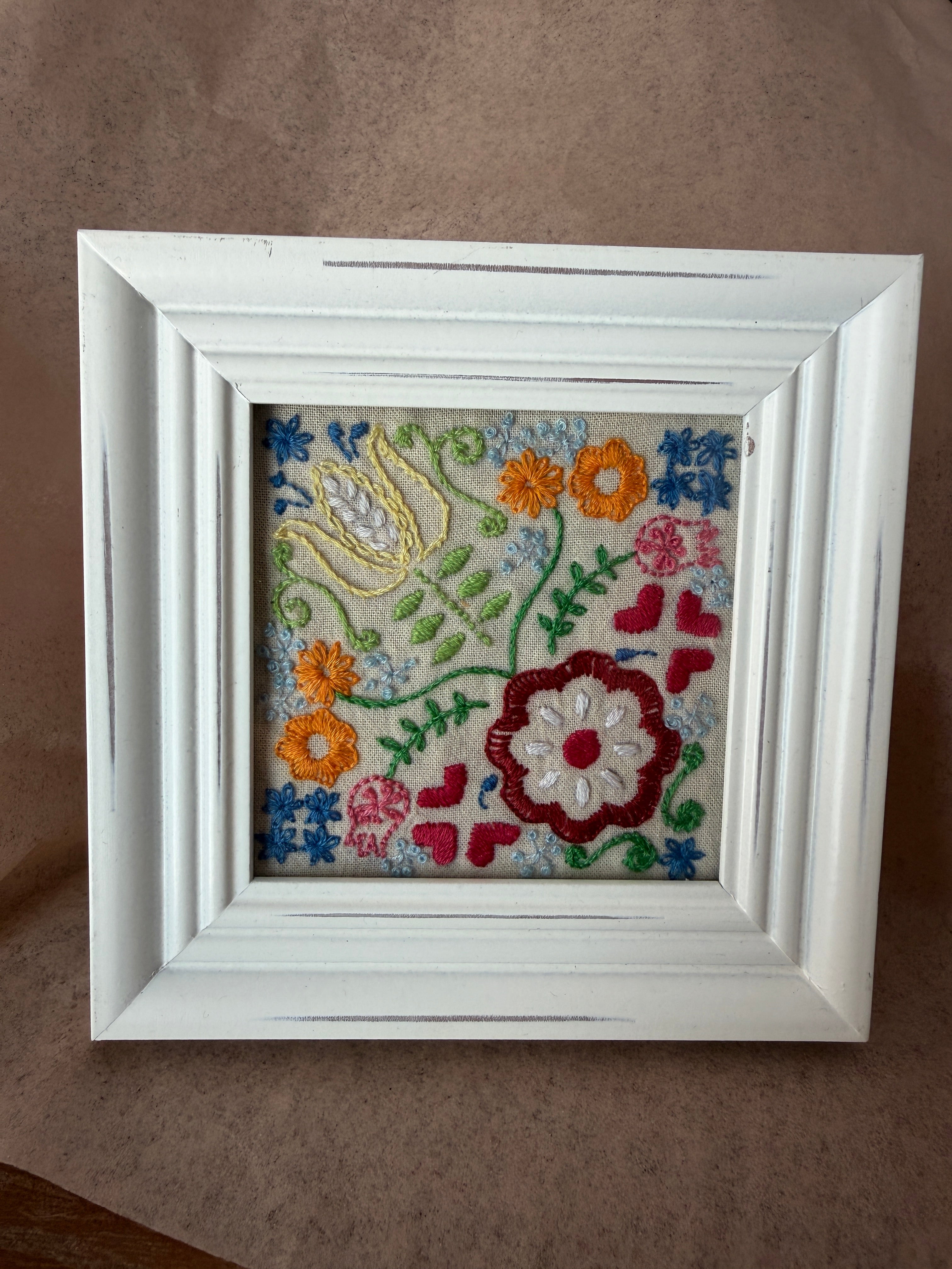 Embroidered garden design in white, square frame